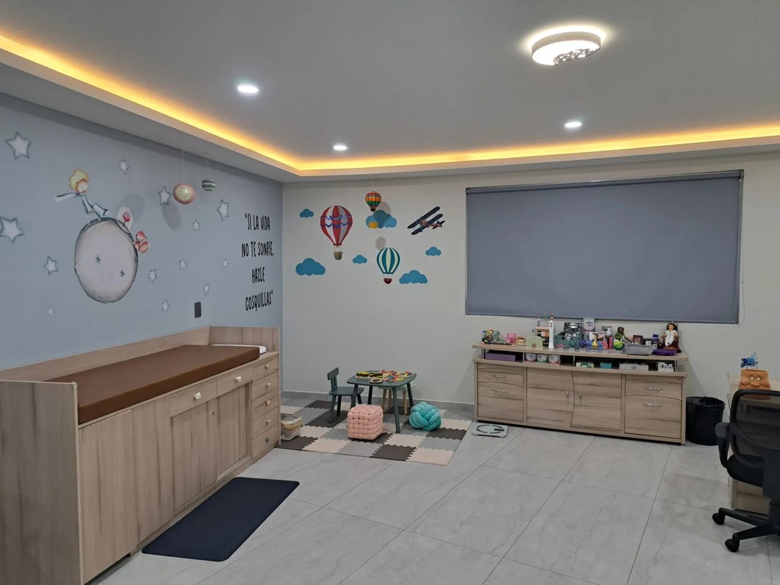 Vista general del consultorio pediátrico con área de juegos y cambiador